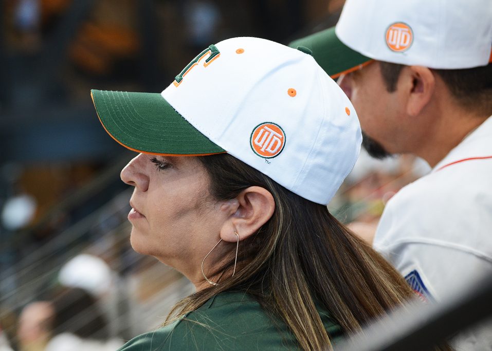 Woman with UTD-themed Texas Rangers baseball cap.