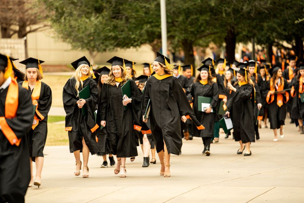 Graduates walking from commencement to the Davidson-Gundy Alumni Center.