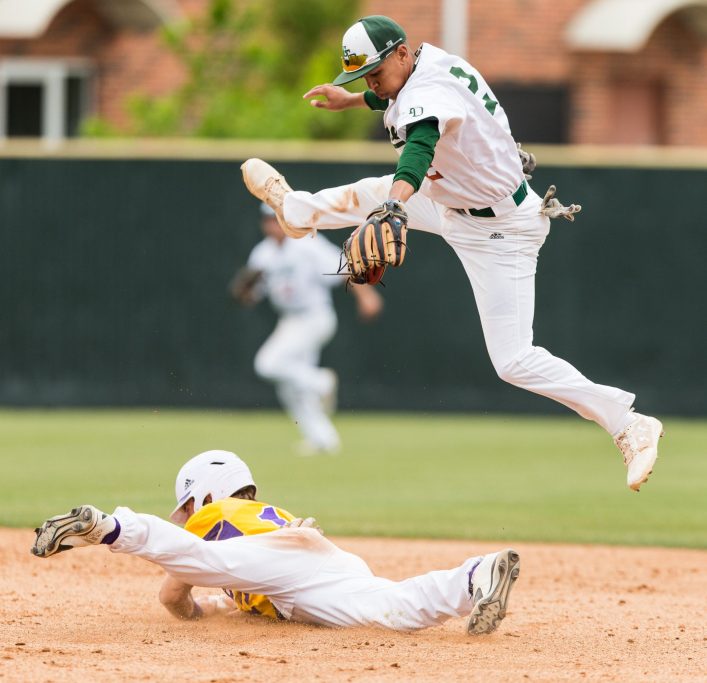 Action shot of Isaiah Swann jumping over another baseball player.