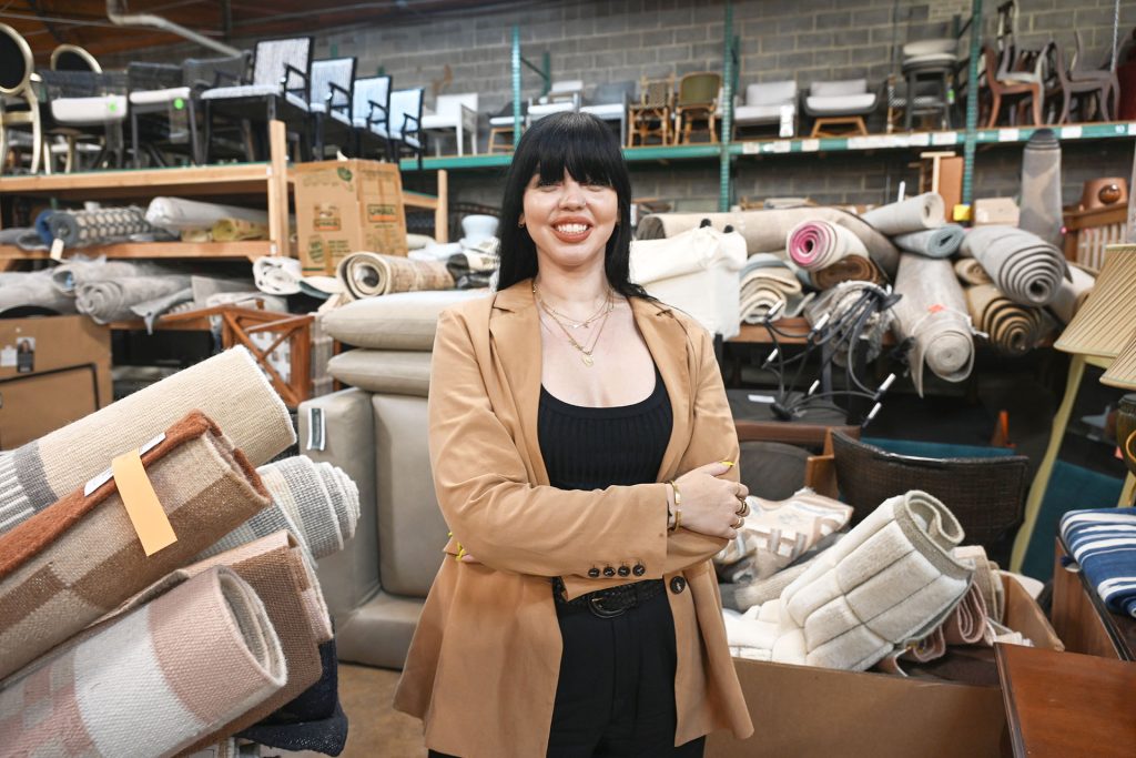 Ashley Sharp posing for a photo in the Dwell with Dignity warehouse in Dallas.