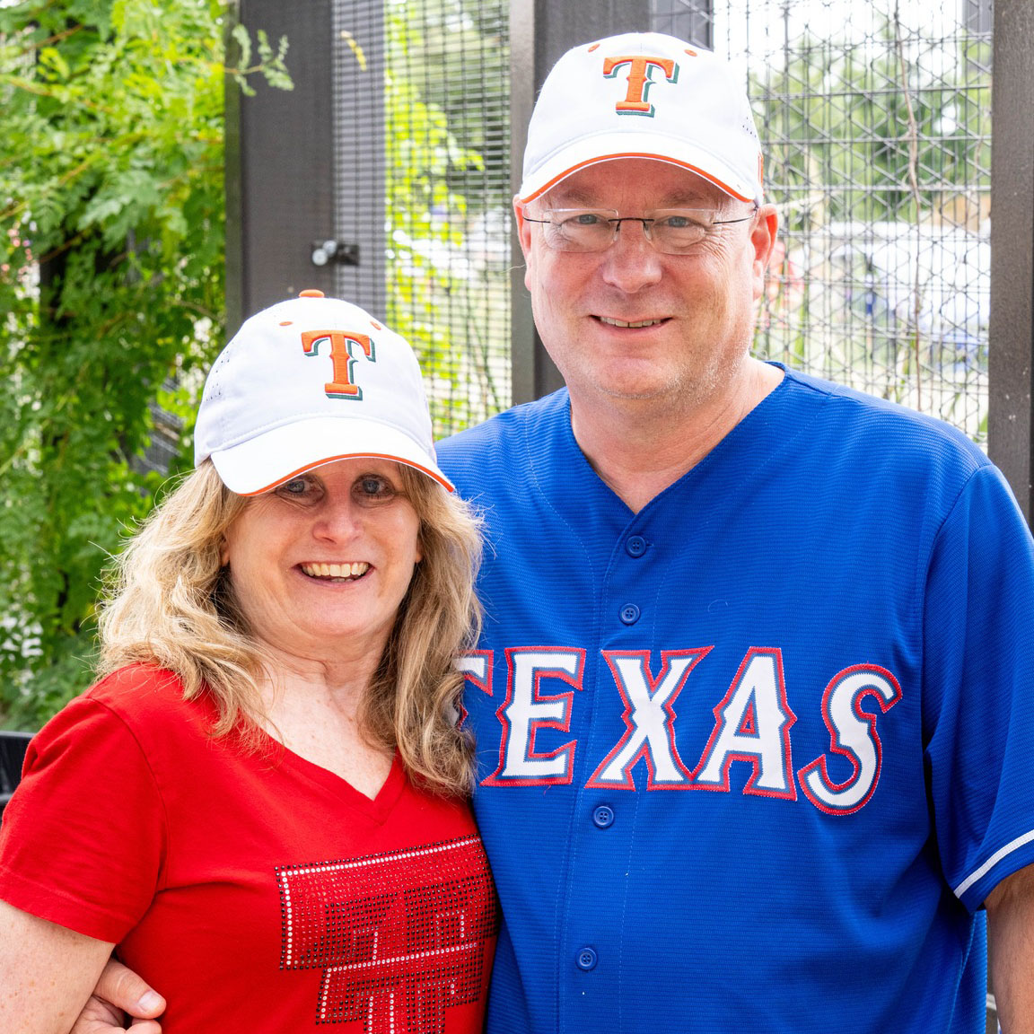 Couple wearing Texas Rangers hats.