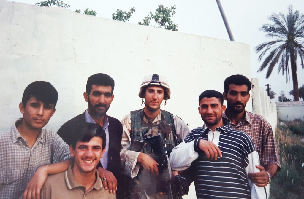 Group photo of Brandon Friedman posing with Iraqis during the war in 2003.