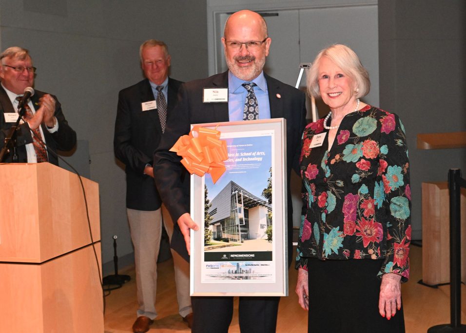 Dr. Nils Roemer presenting a plaque of the school to Doris Bass, wife of the late Harry W. Bass Jr.