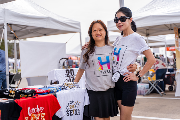 Christi Luu and Jeanny Whu pose for a photo wearing t-shirts they sell.