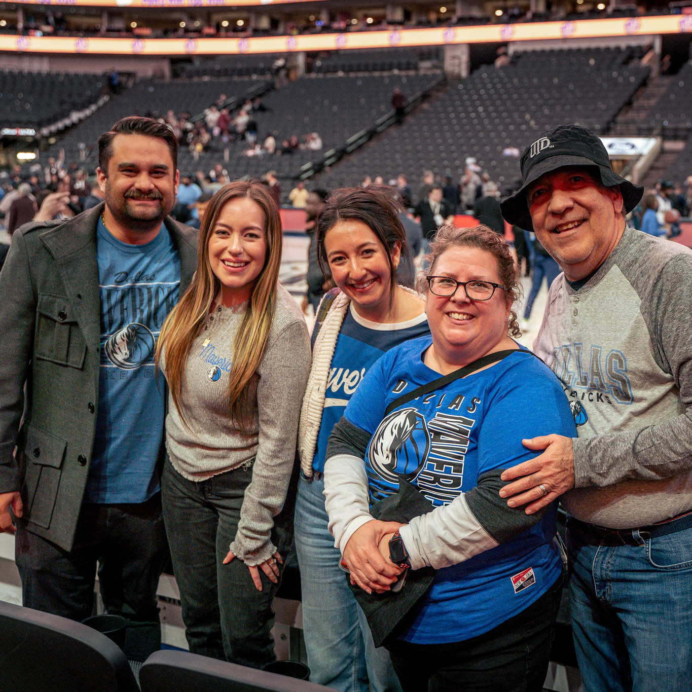 Photo Gallery: UT Dallas Night at the Dallas Mavericks. Group of people posing for a photo at a basketball court.