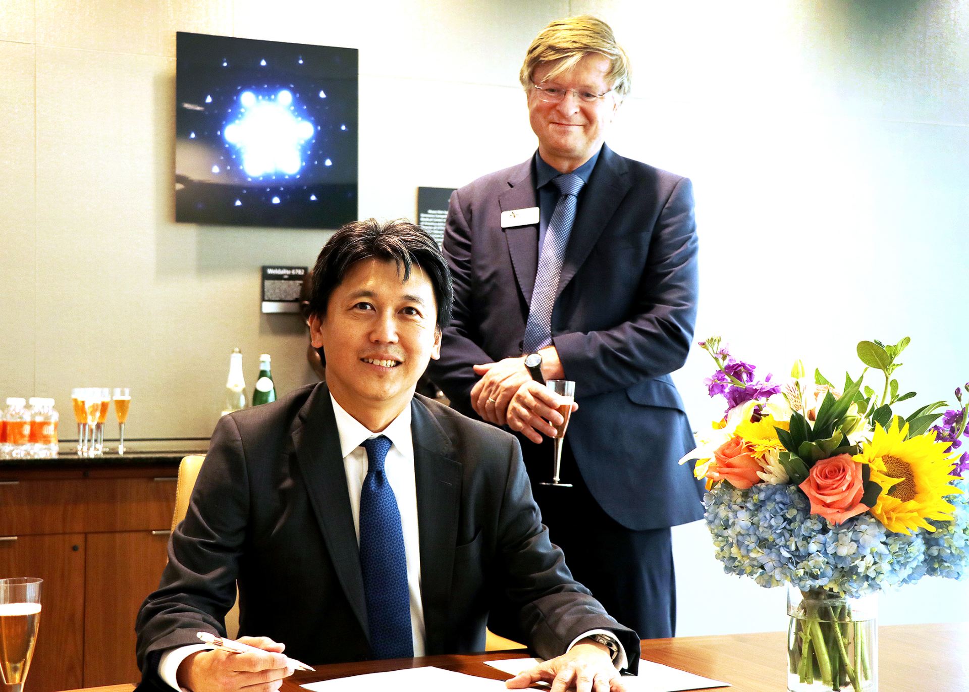 William Huang and Dr. Skinner pose for a photo at a desk.